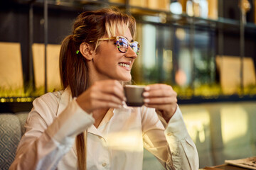 Smiling Woman Enjoying Coffee in a Cozy Modern Cafe