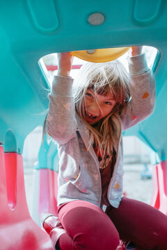 Preschool girl playing on colorful playground structure