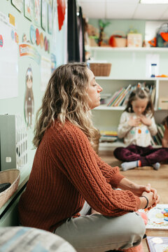 Teacher practicing mindfulness with children in preschool classroom