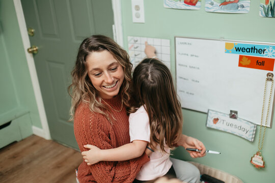 Teacher and preschool student using calendar in classroom lesson