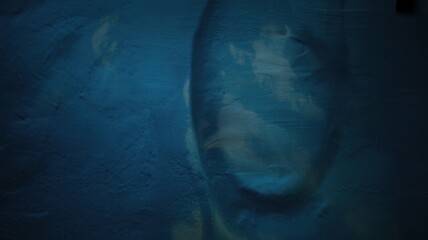 Abstract dark blue textured background with subtle lighter blue and yellow brush strokes, creating a moody and artistic impression, suitable for various design applications