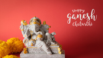 Happy Ganesh Chaturthi festival, Lord Ganesha statue with beautiful texture on red background, Ganesh is hindu god of Success.