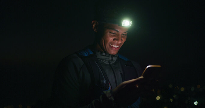 Headlamp, hiking and phone with black man at night to search for directions to destination or location. App, map and navigation with happy hiker outdoor for evening adventure or journey in dark