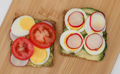 Delicious sandwiches made of whole grain bread with egg, tomato and avocado