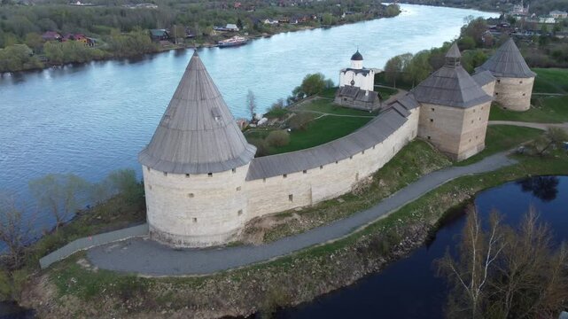 Aerial view of the historic Staraya Ladoga Fortress with stone towers along the riverbank