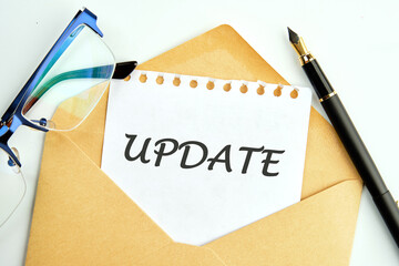 Business concept. UPDATE Word an inscription on a piece of paper peeking out of an envelope next to glasses and a pencil