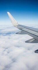 Fototapeta premium Airplane wing over a vast expanse of clouds.