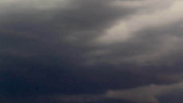 Expansive view of thick storm clouds rolling across the sky with an ominous presence