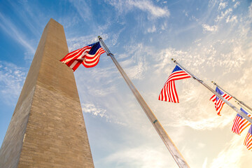 Washington Monument with American flags against sky in Washington DC