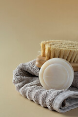 Natural soap and eco brush for body on a soft towel at beige background. natural skin care routine visuals