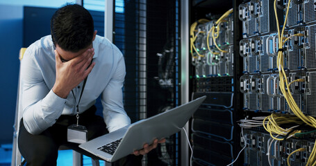 Frustrated man, mistake or stress with laptop in server room for network failure or system error....