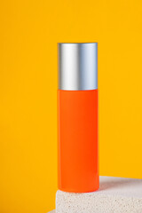 Skin care or sunscreen cosmetic with stylish props on yellow background.