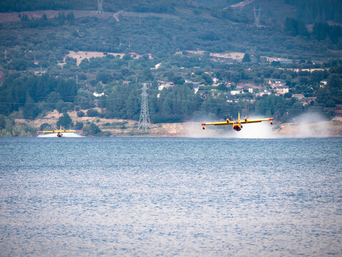 Seaplane begins takeoff after collecting water from the Barcena reservoir while its companion begins maneuvering in the water in El Bierzo