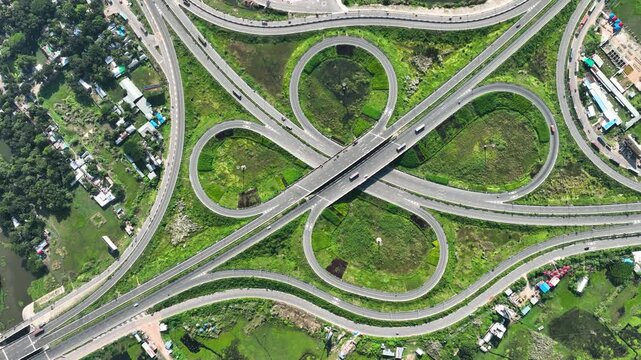 Bhanga, Bangladesh - 21 August 2025: Aerial view of the cloverleaf interchange, a symphony of concrete curves and verdant islands, under the summer sun.