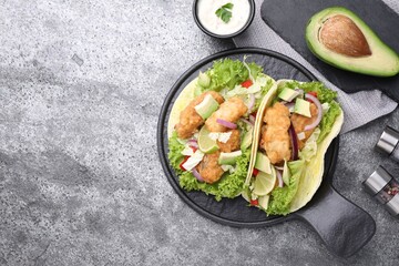 Delicious fish tacos served on grey table, flat lay with space for text