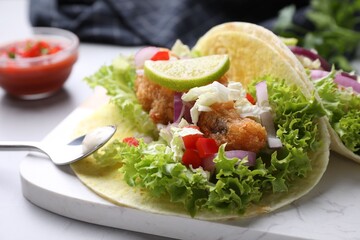 Delicious fish tacos served on light grey table, closeup