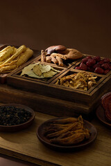 Overhead rustic composition of ginseng roots, jujube, and herbal medicine in a wooden tray. Perfect for illustrating natural remedies. Traditional Chinese Medicine