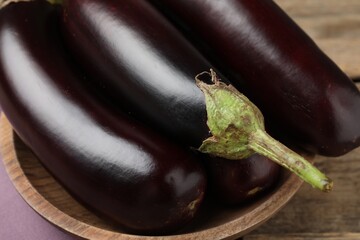 Many ripe eggplants on wooden table, closeup