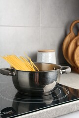 Fresh tagliatelle pasta boiling in pot on electric stove