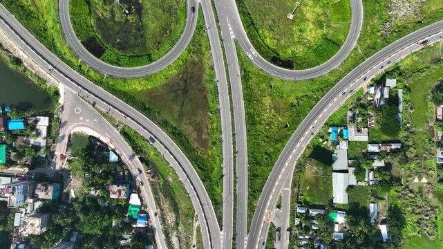 Bhanga, Bangladesh - 21 August 2025: Aerial view of a cloverleaf interchange with lush green spaces, creating a vibrant contrast with the grey concrete roads.