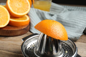Squeezer and oranges on wooden table, closeup. Making fresh juice