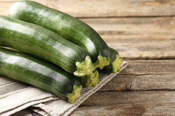Fresh ripe zucchinis on wooden table, closeup. Space for text