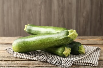Fresh ripe zucchinis on wooden table, closeup