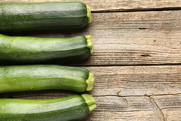 Fresh ripe zucchinis on wooden table, flat lay. Space for text