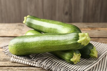 Fresh ripe zucchinis on wooden table, closeup