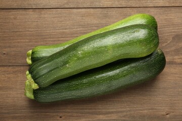 Fresh ripe zucchinis on wooden table, top view