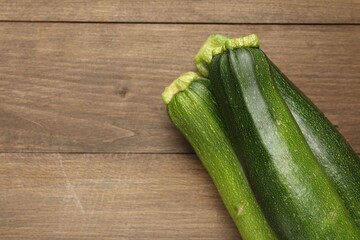 Fresh ripe zucchinis on wooden table, top view. Space for text