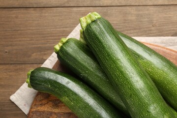 Fresh ripe zucchinis on wooden table, top view. Space for text