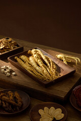 Close-up photo of ginseng roots displayed neatly with herbal ingredients on a wooden background. Soft shadows give an organic look. Herbal medicine photography theme