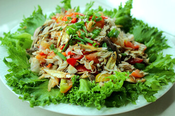 Traditional Thai spicy mackerel and anchovy salad with fresh herbs and vegetables, authentic homemade Thai cuisine, rustic Asian local food photography