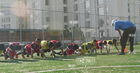 Youth soccer players wearing bibs performing push-ups on turf, with coach guiding and orange cones © vectorfusionart