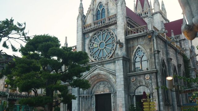 Majestic french style church stands tall amidst lush greenery in ba na hills, showcasing intricate architecture and a captivating rose window, evoking a sense of wonder and tranquility