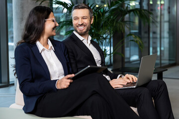 Two colleagues sitting in the office and discussing project details