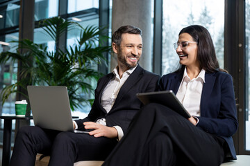 Two colleagues sitting in the office and discussing project details