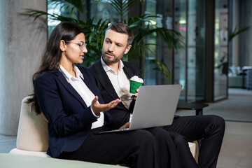 Two colleagues sitting in the office and discussing project details