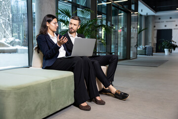 Two colleagues sitting in the office and discussing project details