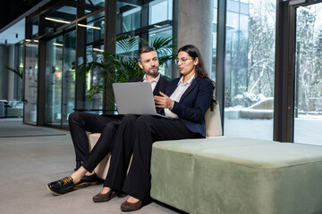 Two colleagues sitting in the office and discussing project details