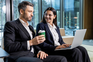 Two colleagues discussing project details and looking involved and interested