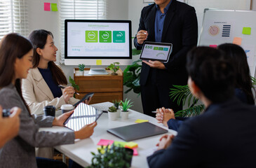 Team of asian business ESG Presentation and Team Collaboration. A professional woman presents ESG metrics to colleagues in a modern meeting room.
