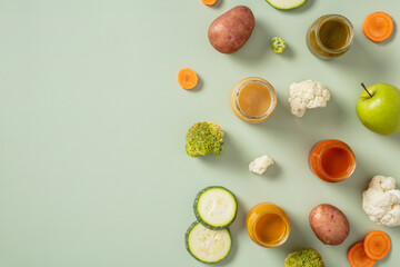 Flat lay healthy baby puree in glass jars with fresh vegetables, fruits on green background