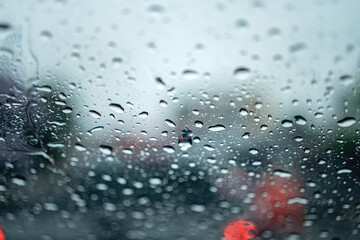 Water or rainy droplet on car windshield glass with blurred background of road traffic jam...