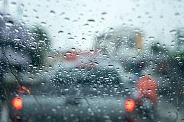 Water or rainy droplet on car windshield glass with blurred background of road traffic jam...