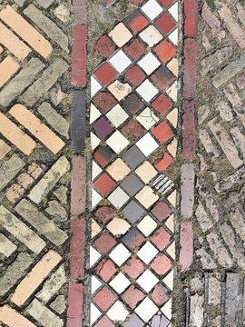 Close-up detail of bright colored brick and tile pavers laid out in contrasing geometric patterns