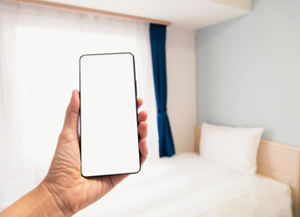 Hand holding mobile phone Blank screen Hotel room blur background Travel agency Advertisement application 