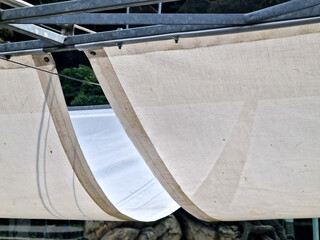square canvas stretched, shading from sun and rain over terrace ofrestaurant, on playground in...