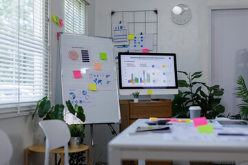 Desktop Computer Monitor with Finance Statistical Data a white-screen mockup for display your graphic is on a white desk in a modern bright living room.	